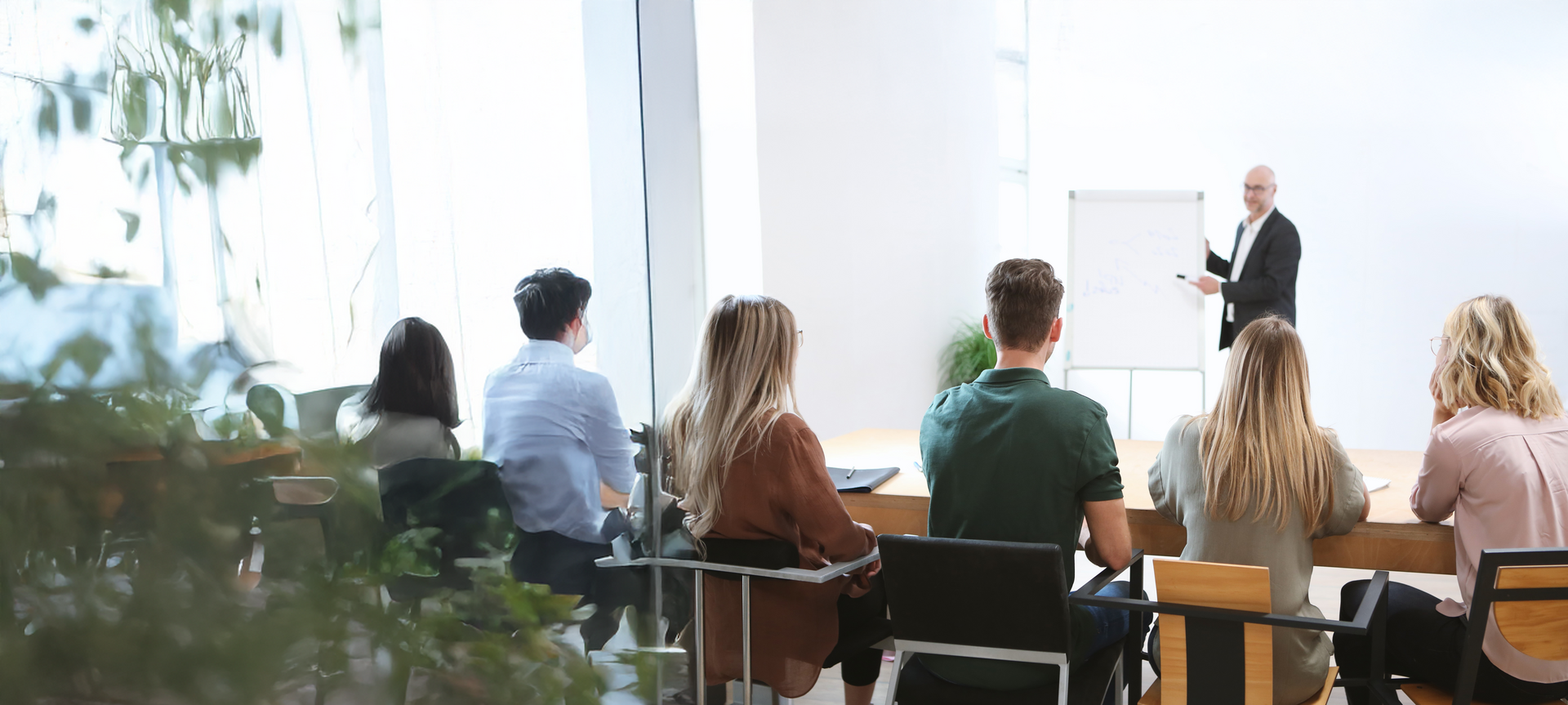 Seminar situation - lecturer stands at the whiteboard Trainees sit in front of it